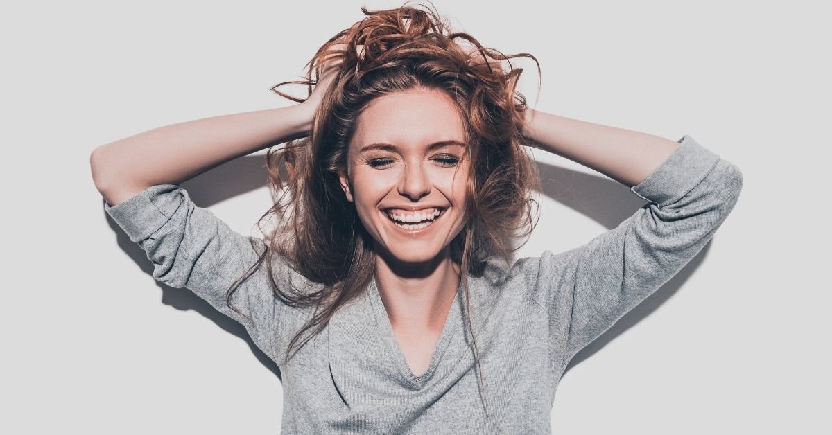 woman smiling holding hair 