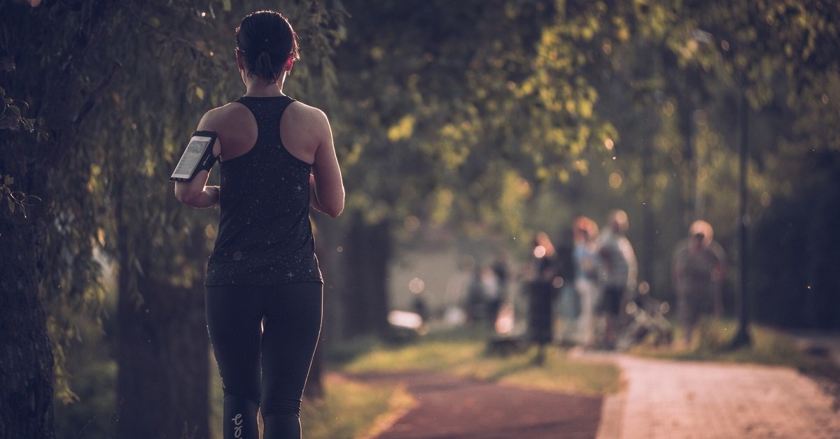 woman running in the park with fitness monitor on